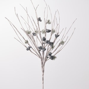 May include: A decorative floral spray featuring thin, light-colored branches with a textured, bark-like appearance. The spray is adorned with small clusters of dark, glittery berries and sparse, needle-like green pine foliage accents.