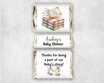 May include: Three wrapped chocolate bars with custom labels. The top label reads "Once upon a time" above a stack of books. The middle label says "Audrey's Baby Shower". The bottom label reads "Thanks for being a part of our Baby's story!"