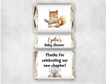 May include: Three chocolate candy bars with custom wrappers. The top wrapper features a watercolor squirrel reading a book. The middle wrapper says "Lydia's Baby Shower". The bottom wrapper says "Thanks for celebrating our new chapter!"
