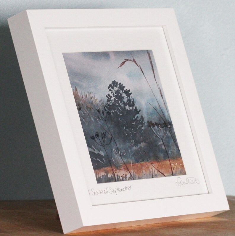 May include: A framed watercolor painting of a landscape with tall grasses and trees in shades of blue and brown. The painting is titled "First of September" and signed by the artist.