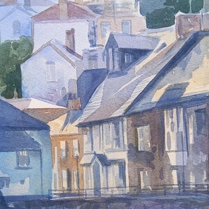 May include: Watercolor painting of a row of houses with slate roofs and white windows. The houses are painted in shades of blue, brown, and beige. The painting is done in a realistic style.