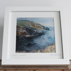 May include: A framed watercolour painting of a rocky coastline with a blue sea. The painting is titled "Lizard Point" and signed by the artist.