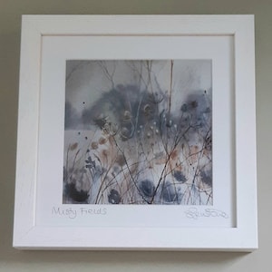 May include: A framed watercolour painting of a misty field with tall grasses and wildflowers in shades of blue, brown, and white. The painting is titled "Misty Fields" and signed by the artist.