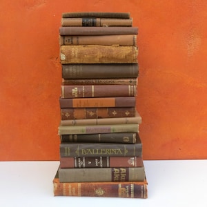 May include: A stack of vintage hardcover books with brown and gold covers. The books have titles like "The Exile", "The Double Traitor", "Hon's", "Toor Mrs. Quack", "Ballerina", and "Aku Aku".