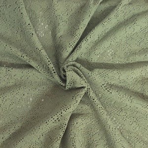 May include: A close-up of a sage green crocheted fabric with a delicate openwork pattern.