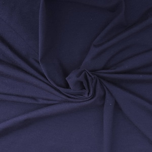 May include: A close-up of a dark blue fabric with a soft, smooth texture. The fabric is folded and draped, creating a sense of movement and flow.