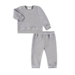 May include: A light gray, two-piece children's outfit. The set includes a long-sleeved sweatshirt and matching sweatpants. The sweatshirt has a crew neck and ribbed cuffs and hem. The sweatpants have an elastic waistband and ribbed cuffs.