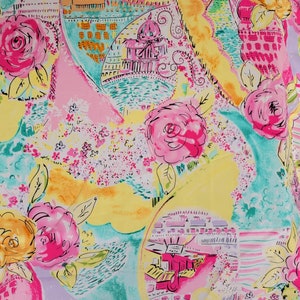 May include: A colorful fabric featuring a watercolor design with pink roses, architectural elements, and abstract shapes in yellow, pink, and teal. The pattern includes floral and cityscape motifs.
