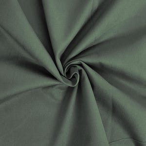 May include: A close-up of a dark green fabric with a smooth texture. The fabric is folded and draped, creating a soft, flowing look.