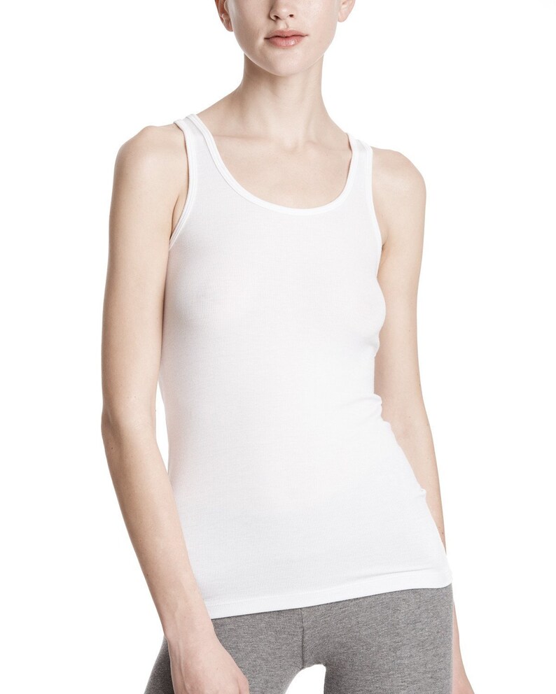 May include: A white ribbed tank top with a scoop neck and thin straps.