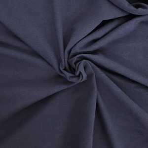 Puede incluir: Una tela de color azul marino oscuro s&oacute;lido con un acabado mate, que presenta una textura suave y pliegues naturales que crean un patr&oacute;n arremolinado y fruncido en la superficie. El material parece opaco y uniforme, con sutiles luces y sombras.