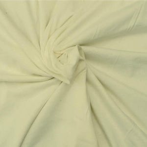 Puede incluir: Una tela de color crema claro s&oacute;lido con una textura suave y mate. El material est&aacute; recogido en el centro, creando pliegues y drapeados naturales que irradian hacia afuera a trav&eacute;s de la superficie, resaltando el color suave y consistente.