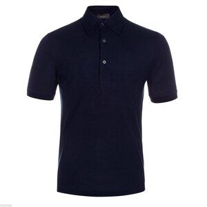 May include: A navy blue polo shirt with short sleeves. The shirt has a collared neckline and a three-button placket. The fabric appears to be a soft knit material. The shirt is a solid color with no visible patterns or graphics.