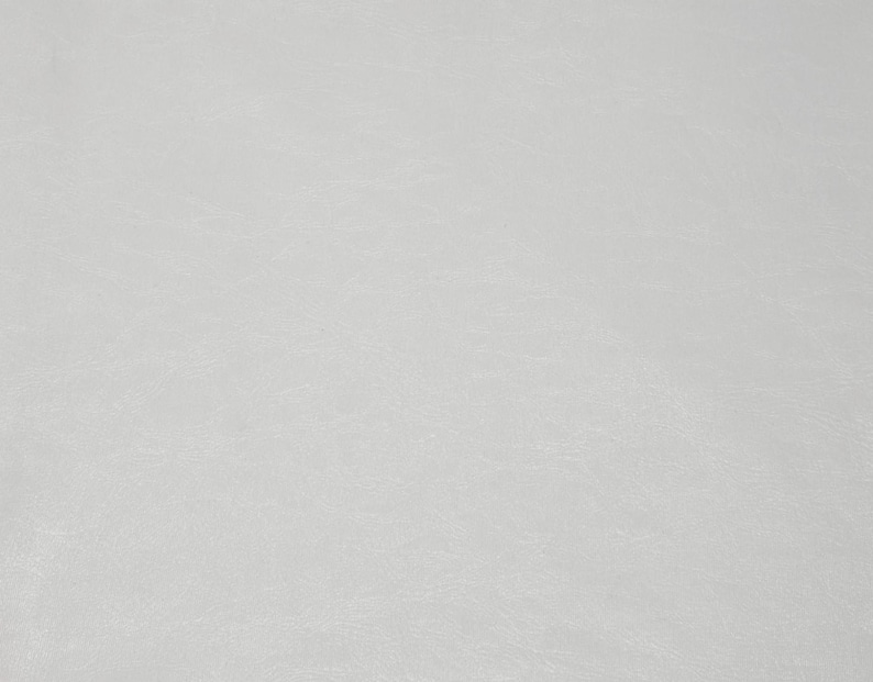 Pode incluir: Um close-up de uma superf&iacute;cie texturizada em branco sujo. A superf&iacute;cie parece ser couro ou material semelhante, com varia&ccedil;&otilde;es sutis de tom e textura. A ilumina&ccedil;&atilde;o &eacute; suave, criando uma apar&ecirc;ncia suave e uniforme.