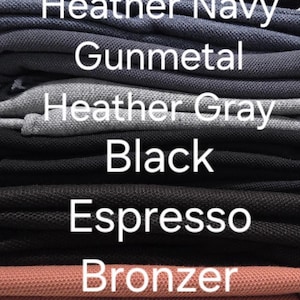 May include: A stack of folded fabric in various colors, including indigo, heather navy, gunmetal, heather gray, black, espresso, bronzer, and cream. The names of the colors are displayed in white text.