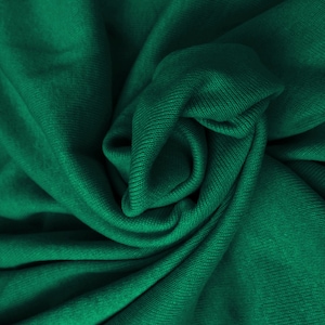 May include: A close-up of a deep green fabric with a textured, ribbed surface. The fabric is folded and draped, creating soft, flowing lines.