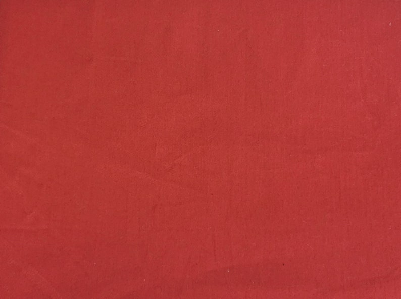 Pu&ograve; includere: Uno sfondo di tessuto rosso solido con una texture liscia.