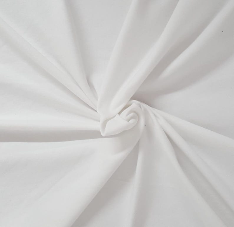 May include: A solid white fabric featuring a smooth, matte texture. The material is gathered at the center, creating soft, radiating folds and deep shadows that extend outward toward the edges, highlighting the clean, bright white color.