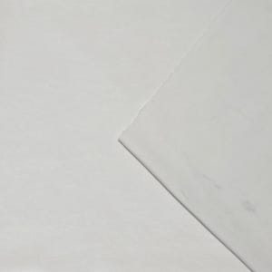 Pode incluir: Um close-up de tecido branco com uma superf&iacute;cie ligeiramente texturizada. O tecido &eacute; dobrado na diagonal, revelando uma borda em camadas. A ilumina&ccedil;&atilde;o cria sombras sutis, destacando a textura e as dobras.