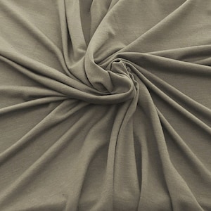 May include: A close-up of a soft, smooth, light brown fabric with a swirling pattern.