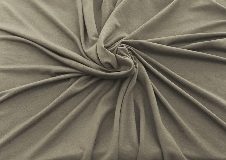 May include: A close-up of a soft, smooth, light brown fabric with a swirling pattern.