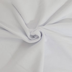 May include: A close-up shot of a white fabric with soft folds and a spiral at the center. The fabric appears to be a smooth, possibly absorbent material, with subtle variations in texture and tone.