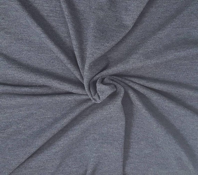 May include: Close-up of a gray fabric with a subtle texture. The fabric is gathered and twisted, creating a swirl effect. The color is a solid, medium gray, with soft shadows and highlights.
