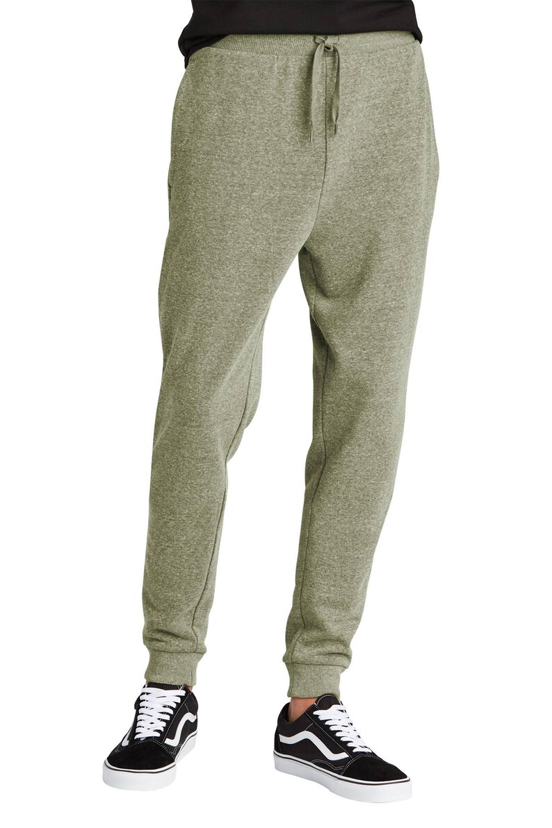 May include: Olive green sweatpants with a drawstring waist and ribbed cuffs. The pants are paired with black and white sneakers. The casual pants are made of a soft, comfortable material.