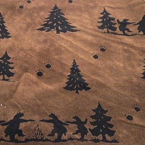 May include: Brown fabric with a repeating pattern of black silhouettes of bears holding hands, pine trees, and bear paw prints. The fabric has a textured appearance.