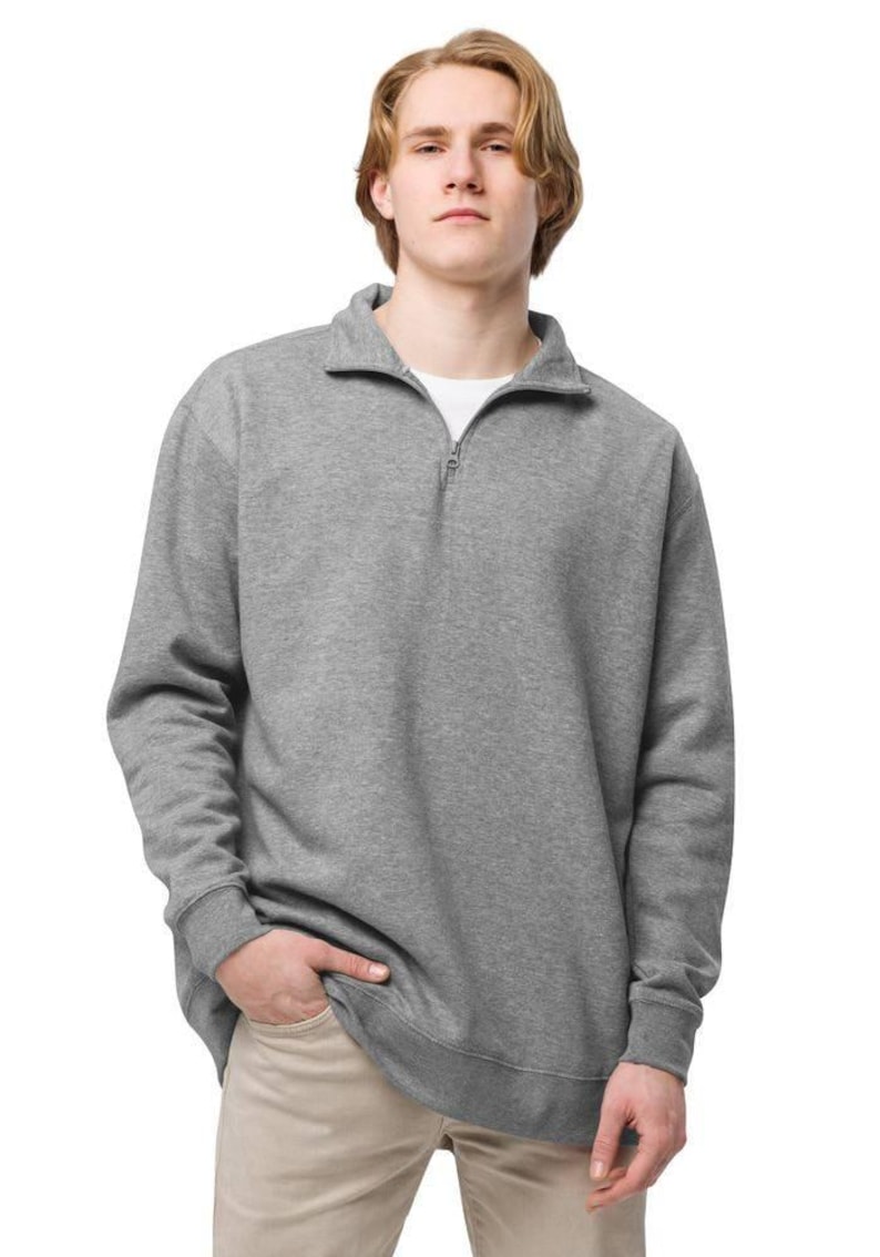May include: A gray sweatshirt with a quarter-zip collar. The long-sleeved top has a relaxed fit and ribbed cuffs. The model is wearing a white undershirt and khaki pants. The sweatshirt is a versatile piece of casual apparel.