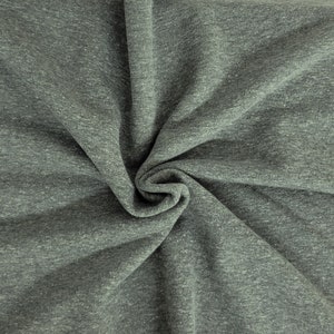 May include: A close-up shot of a gray fabric with a subtle heathered texture. The fabric is draped and folded, creating soft shadows and highlighting the material's flexibility. The overall appearance suggests a comfortable, versatile textile suitable for apparel or home decor.