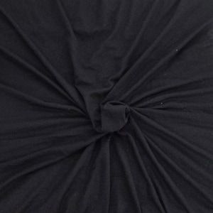 May include: A close-up shot of a black fabric, knotted in the center. The fabric has a soft, flowing texture with visible folds and creases. The dark color and the way the fabric is gathered suggest it could be a piece of clothing or a decorative textile.