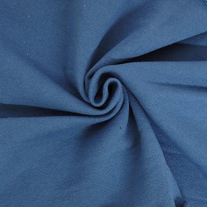 May include: Close-up of a swirl of blue fabric. The fabric appears to be a soft knit material, with visible texture and slight variations in the blue hue. The folds create a dynamic, swirling pattern.