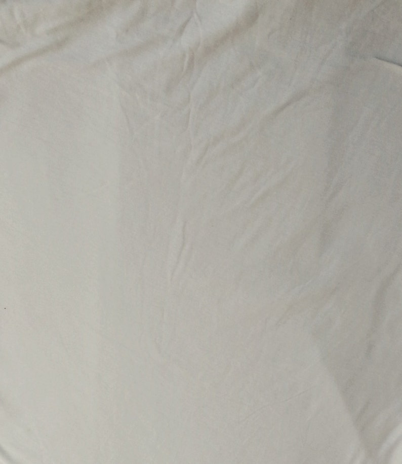 May include: A plain white fabric surface with a smooth texture.