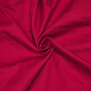 May include: A solid, deep magenta fabric with a soft, matte texture. The material is gathered in the center, creating natural, flowing folds and shadows that radiate outward, highlighting the consistent, vibrant color across the entire surface.