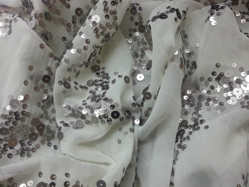 May include: White sheer fabric with silver sequins scattered across the surface.