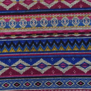 May include: A colorful fabric with a geometric pattern in shades of blue, pink, gold, and black. The pattern is reminiscent of traditional Native American designs.