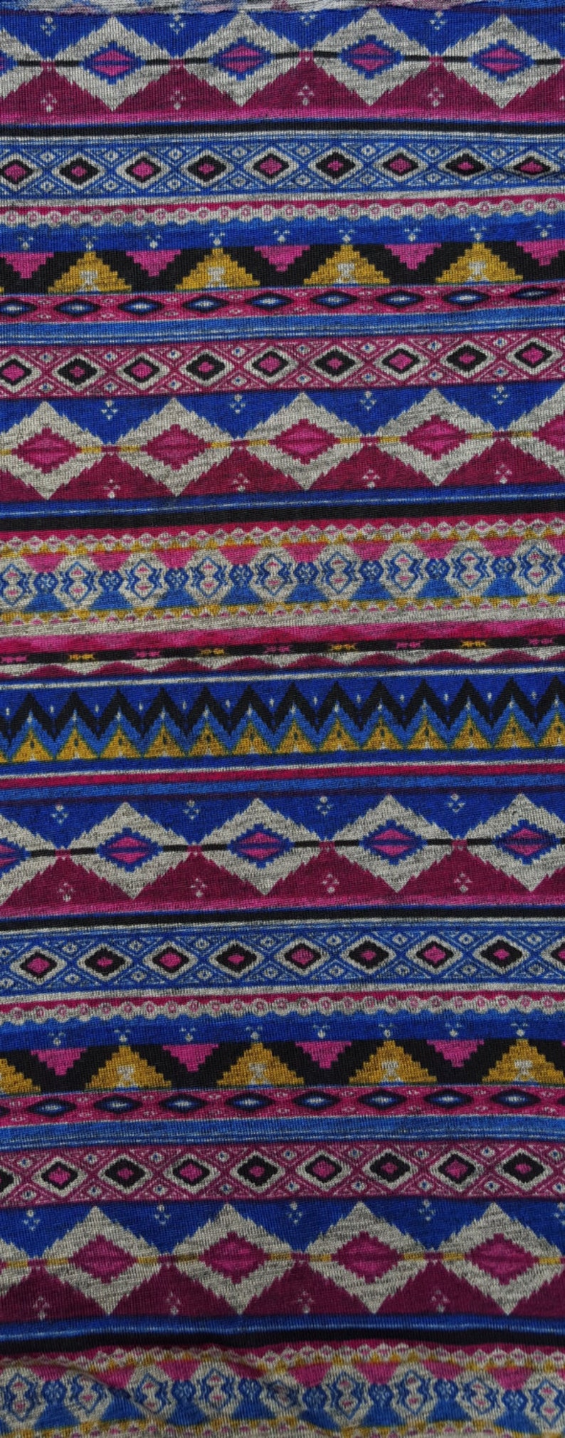 May include: A colorful fabric with a geometric pattern in shades of blue, pink, gold, and black. The pattern is reminiscent of traditional Native American designs.