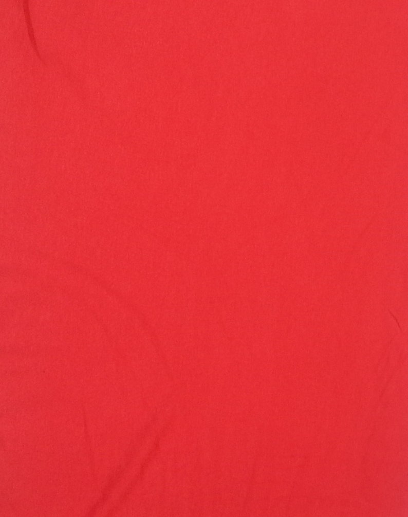 May include: Solid red fabric with a smooth texture. The fabric is slightly wrinkled.