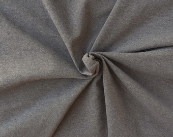 May include: Close-up of a gray, textured fabric with a swirling pattern.