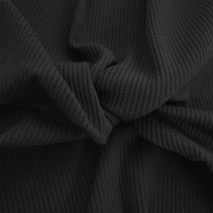 May include: Close-up of black ribbed fabric with a textured surface.