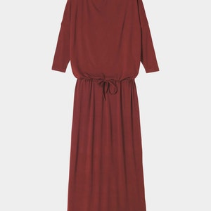 May include: A long, burgundy-colored dress with a drawstring waist and three-quarter sleeves.
