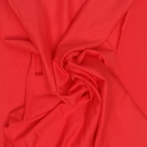 May include: A close-up of a bright red fabric, showing the texture and folds of the material.
