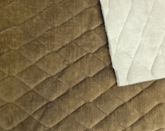 May include: Close-up of a brown quilted fabric with a diamond pattern. The fabric is shown next to a white quilted fabric with a diamond pattern.