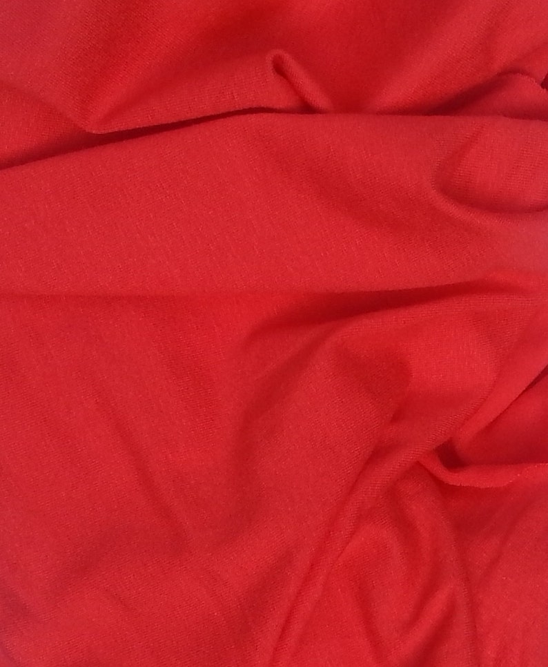 May include: A close-up of a smooth, red fabric with a soft, textured surface.