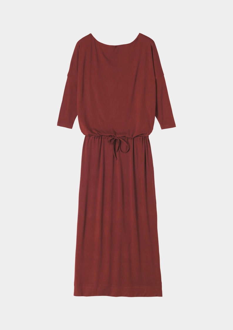 May include: A long, burgundy-colored dress with a drawstring waist and three-quarter sleeves.