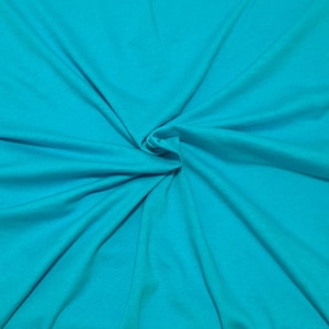 Puede incluir: Una tela de color turquesa s&oacute;lido con una textura suave y mate. El material est&aacute; recogido en el centro, creando pliegues naturales y radiantes junto con sombras suaves que se extienden hacia los bordes del marco, resaltando el color.