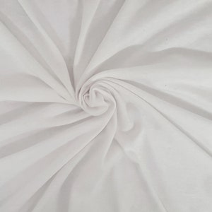 May include: White fabric with a smooth, silky texture. The fabric is draped and folded, creating soft, flowing lines.
