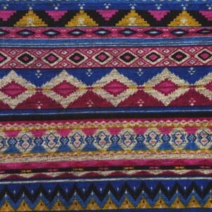 May include: A close-up of a fabric with a colorful geometric pattern. The pattern is made up of stripes of different colors, including blue, pink, gold, and black. The fabric has a textured surface.
