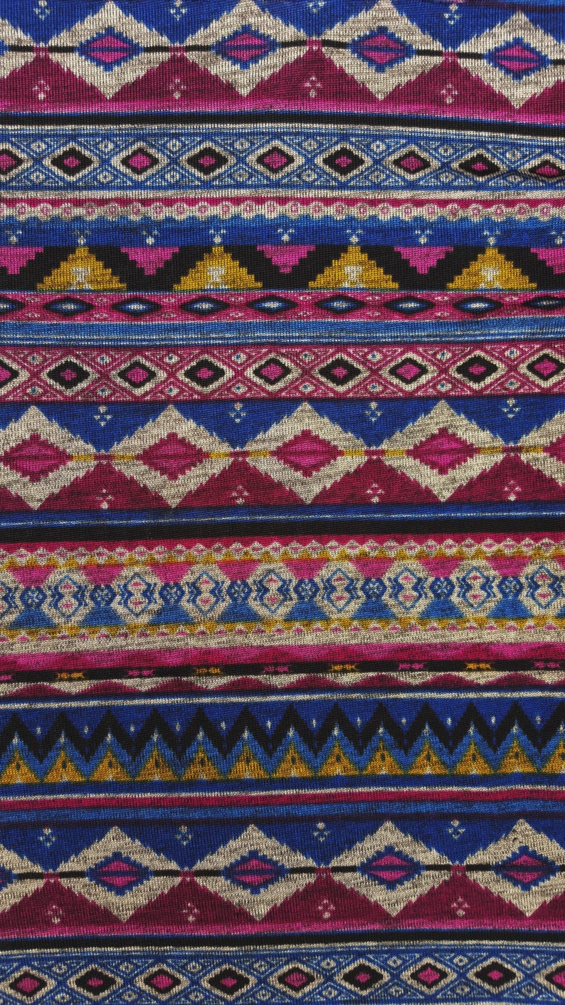 May include: A close-up of a fabric with a colorful geometric pattern. The pattern is made up of stripes of different colors, including blue, pink, gold, and black. The fabric has a textured surface.